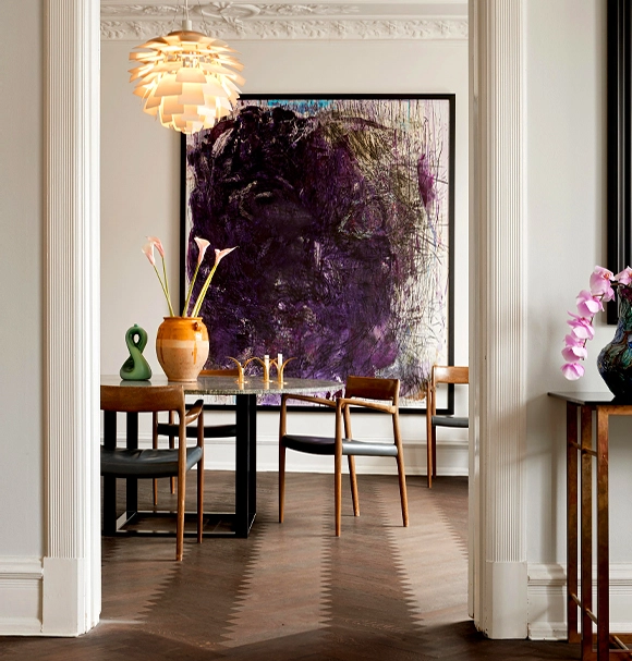 Interior of a dining with an Artichoke Lamp and purple painting Purple painting and Artichoke Lamp in dining room interior
