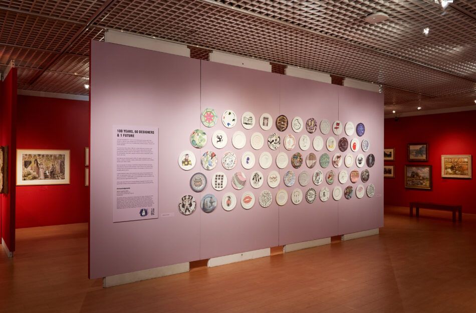 Fliederfarbene Wand in der Galerie mit montierten Tellern