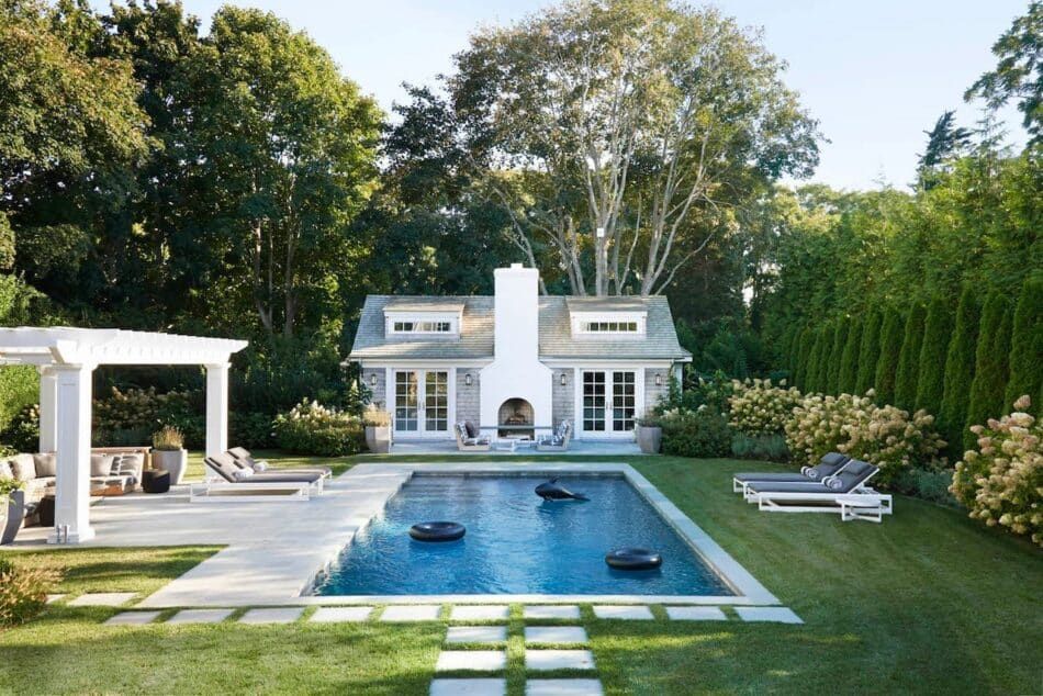 un pool house de style Shingle conçu par Jessica Ayromloo, à côté d'une piscine