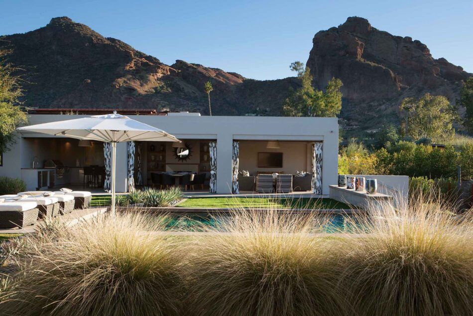 A white adobe-inspired pool house with interiors by MMB Studio