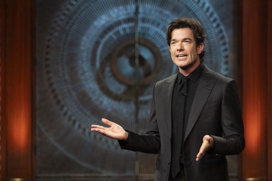 John Mulaney presents his monologue on Everybody's Live with John Mulaney in front of a pair of Brutalist doors 
