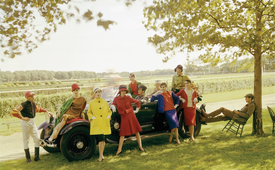Models in Norman Norell sporty daytime outfits in vivid fall hues, shot at the Belmont Racetrack in 1960.