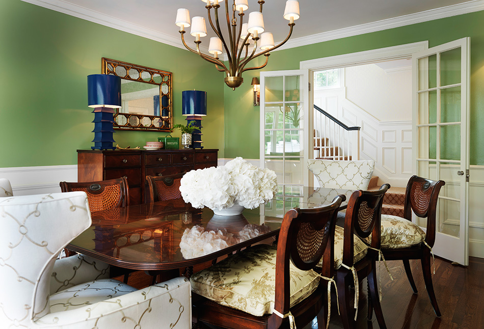 Tradition meets the unexpected in the dining room of a Wellesley, Massachusetts, home, where the Kravat fabric on the wingchairs, the multi-armed chandelier and the pair of porcelain pagoda lamps add a dose of whimsy. Photo by Nat Rea