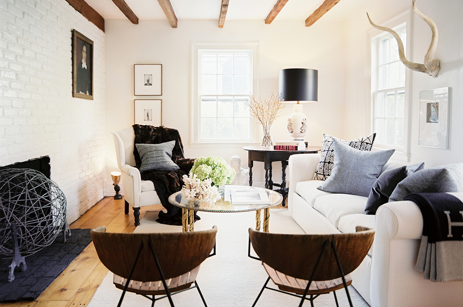 In the living room of a Sag Harbor house, metal-and-rush 1950s chairs by Arthur Umanoff face framed photos by Lyle Owerko on the far wall. Photo by Patrick Cline, courtesy of Lonny