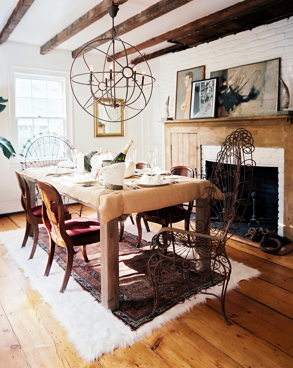 In the dining room of the Sag Harbor house, vintage Regency dining chairs are paired with sculptural metal chairs from Mexico. Photo by Patrick Cline, courtesy of Lonny