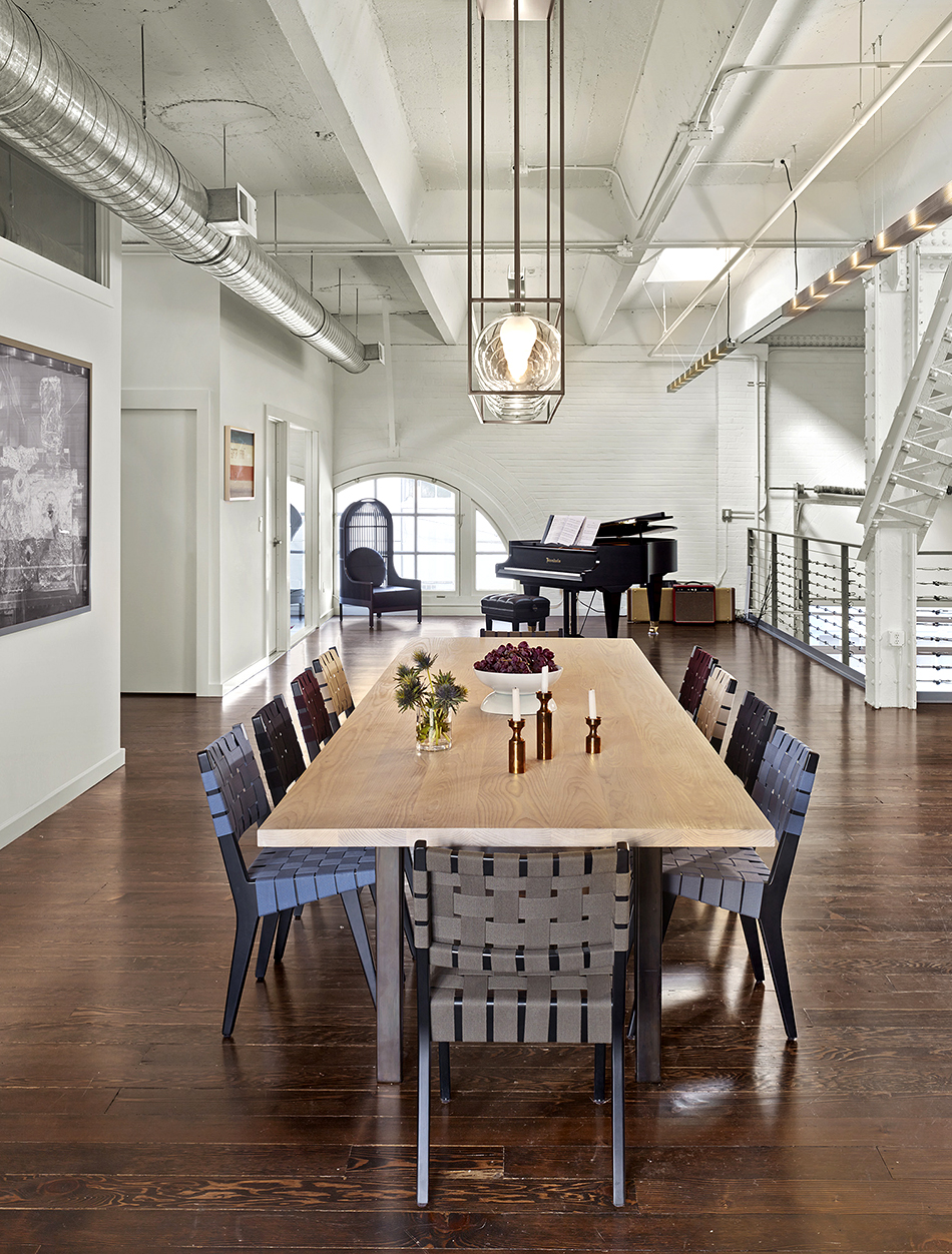 Geremia Design custom-made the light fixture and table in this combined gallery-living space, converted from a firehouse, in San Francisco’s SoMa district. The dining chairs are vintage Jens Risom. Photo by Cesar Rubio