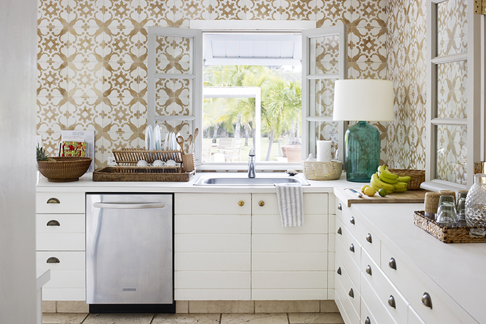 In a different Harbour Island house, the designer placed custom-made, swing-in casement windows from France in the kitchen, opening it to the outdoors. The walls are covered in Cuban tiles.