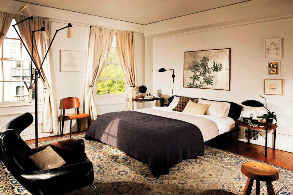 The designer’s own bedroom features a Prouvé standard chair and an elliptical side table by Alain Richard illuminated by an Arteluce floor lamp. Photo by Mary Nichols
