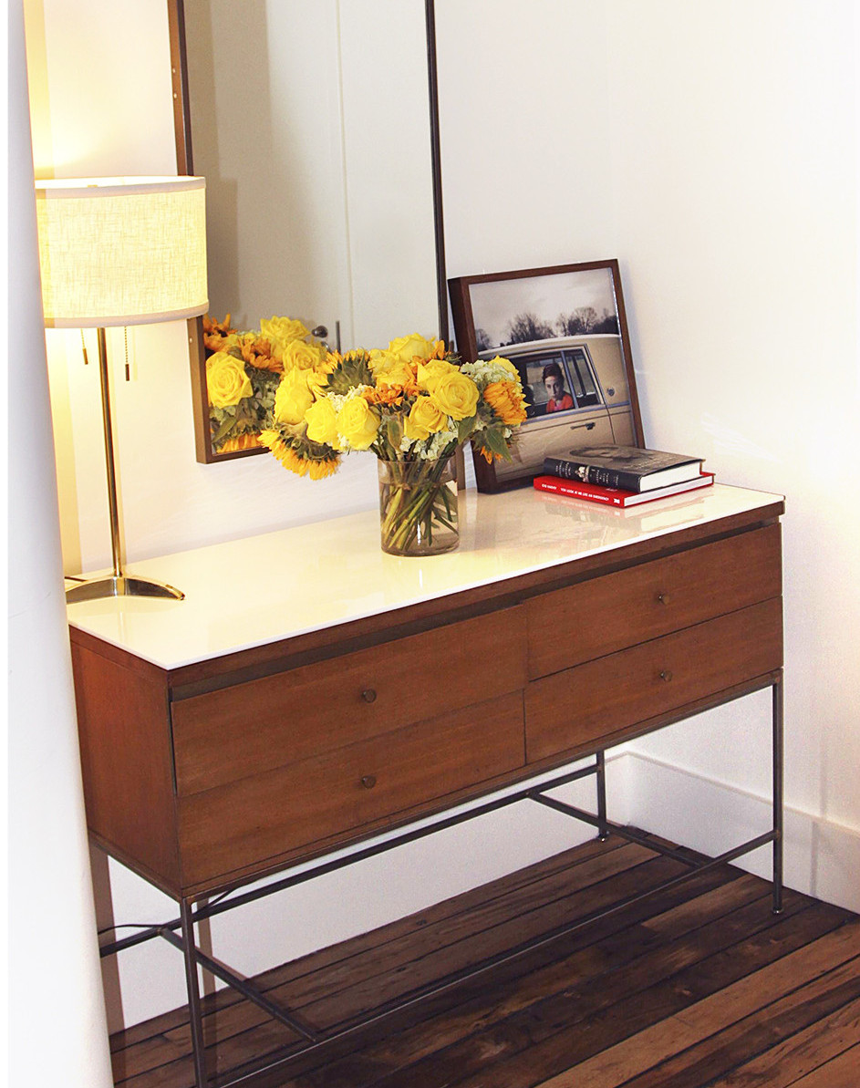 Despite Hughes’’s initial doubts, the McCobb console (newly topped with a slab of milk glass) looks right at home in the loft, paired with a McCobb mirror, a lamp from Rumba and a photograph by Cig Harvey from Robin Rice Gallery. Photo by Kathleen Hughes