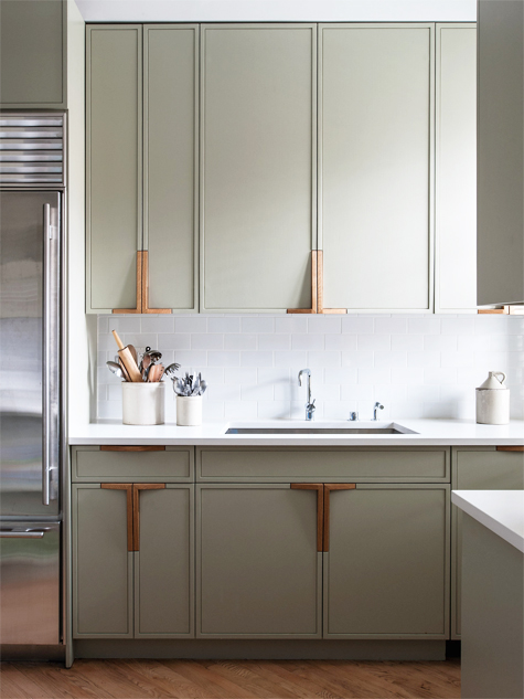 In this Park Slope kitchen, the plumbing fixtures are by Vola, and the cabinet faces are painted in Farrow & Ball’s French Gray; the firm designed the handles to pick up the color of the wood floors.