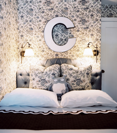 In a young girl’s room, a traditional floral-print Cowtan & Tout fabric does double-duty on the walls and pillows. The designers found the “C” at a local vintage shop, and the Scallop bedding is by Matouk. Photo by Patrick Cline