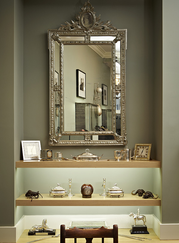 Non-jewelry items on offer include, from left on the top shelf: a weather station clock by Auricoste, ca. 1930; a George III silver warming dish, 1778; a desk clock by Cartier, ca. 1930. A pair of George II silver candlesticks by John Café, ca. 1740, and George III silver tureens by Solomon Hougham, ca. 1787, sit on the shelf below.