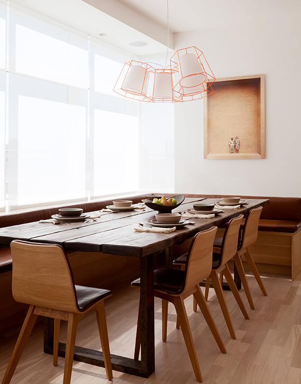 A built-in dining nook in the corner of a residence in New York’s West Village features a custom table made of salvaged wood and steel. Photo by Ball & Albanese