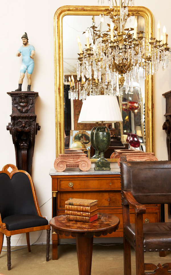 A pair of South American figures flank a Russian chandelier and a French Louis Philippe gilt-wood mirror, all from the 19th century.