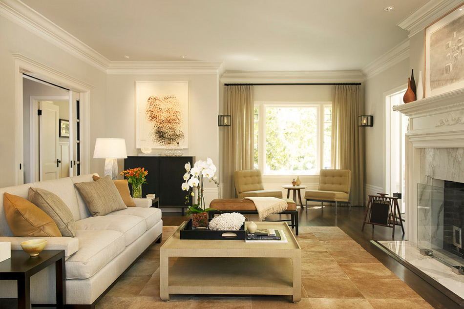 Traditional architectural details are a backdrop for furnishings with clean lines, upholstered in a mix of butterscotch, gray and linen tones. Photo credit: Patrik Argast