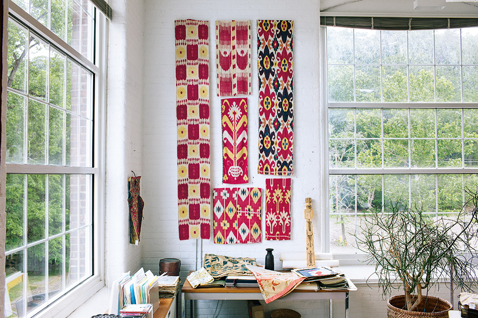 TK TEXTILES SPECIFICS ON FABRICS hang over a desk, set off against a white-painted brick wall at the library’s headquarters. Photo by Mark Mahaney