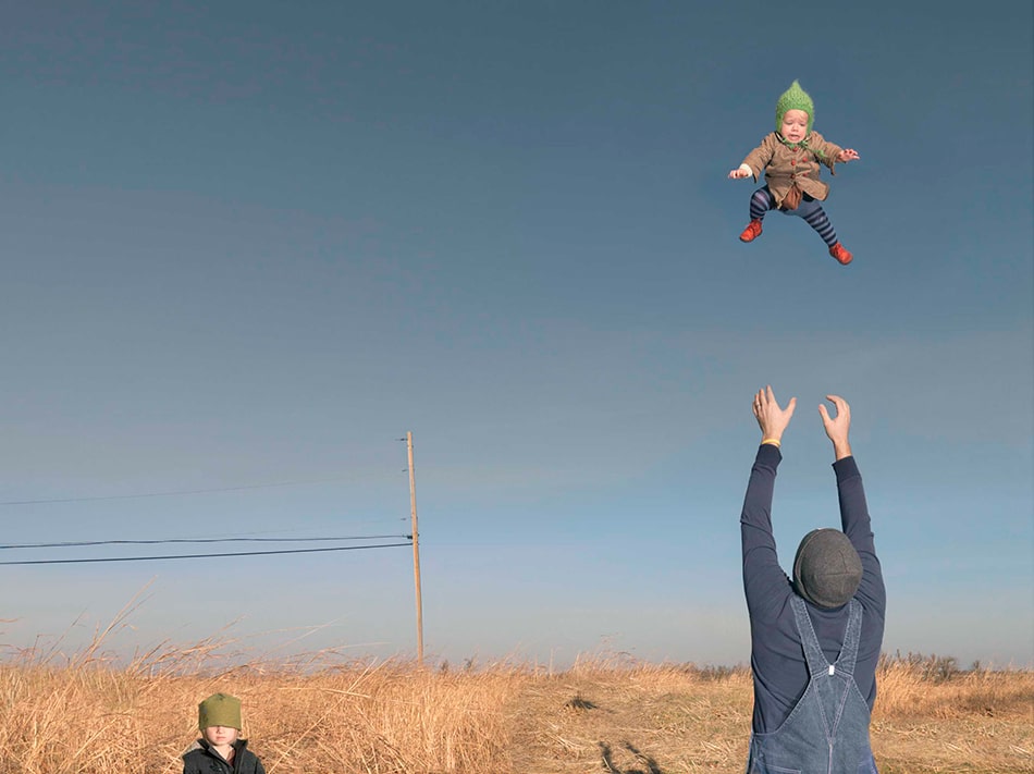 man tossing baby