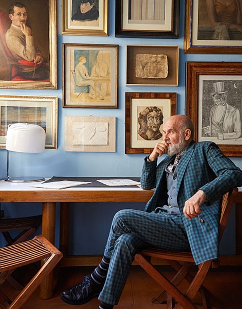 Barnaba Fornasetti sits before a collection of paintings by his father.