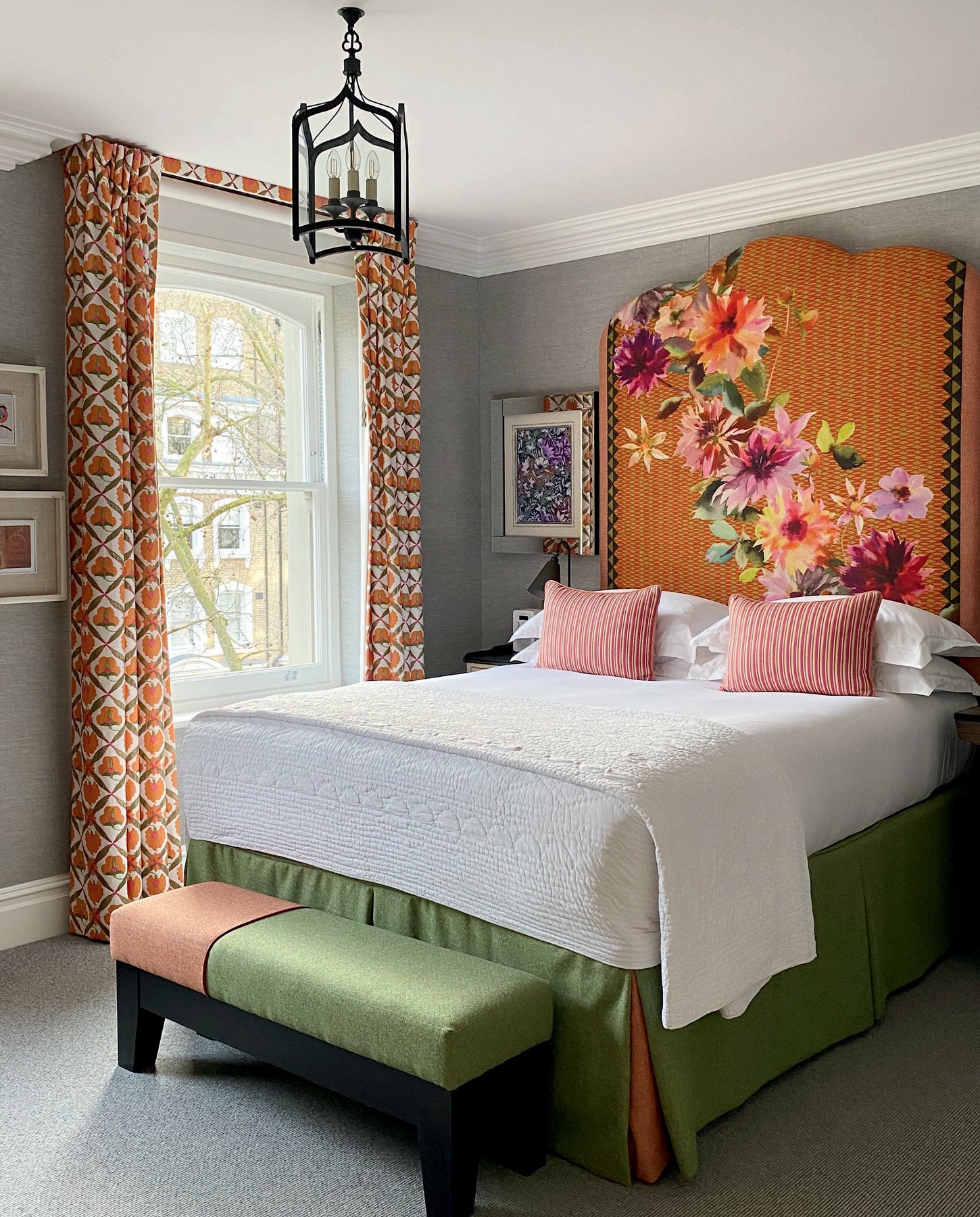 Schlafzimmer mit hohem, floral bedrucktem Kopfteil