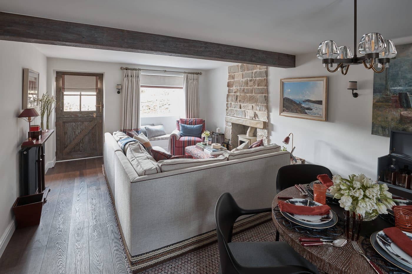 salle de séjour d'un cottage rustique avec poutre en bois et cheminée en pierre, décorée par Katharine Pooley