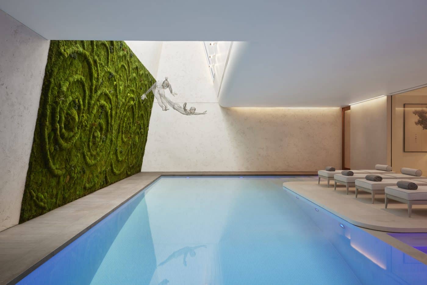 Indoor-Pool mit grüner Wand und Hängeskulpturen, gestaltet von Katharine Pooley