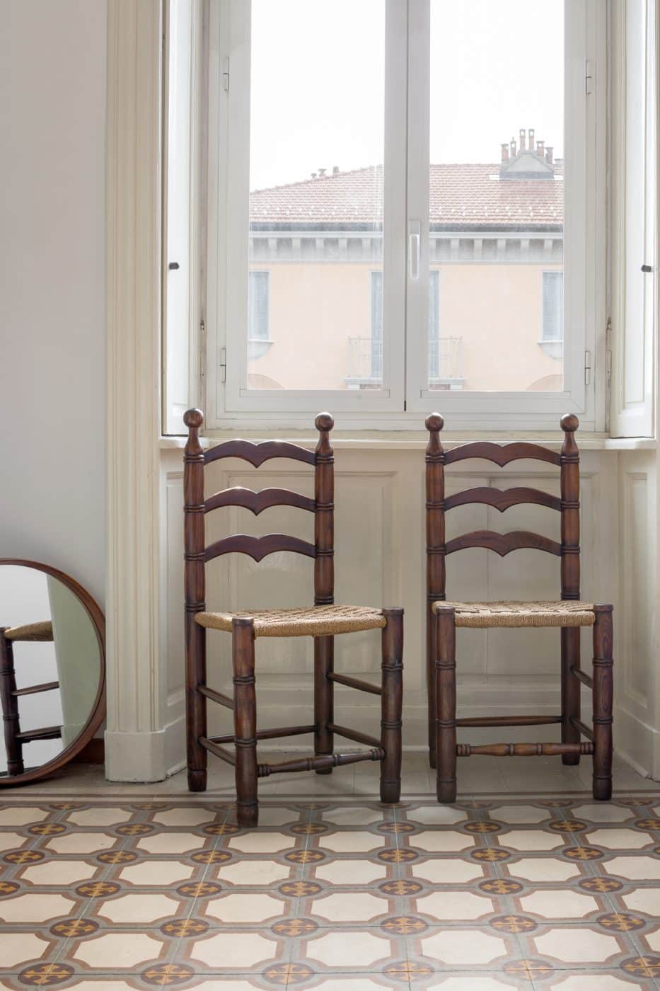 Zwei Eichenstühle von Calligaris aus den 1950er-Jahren unter einem Fenster in Jenny Waltons Wohnung