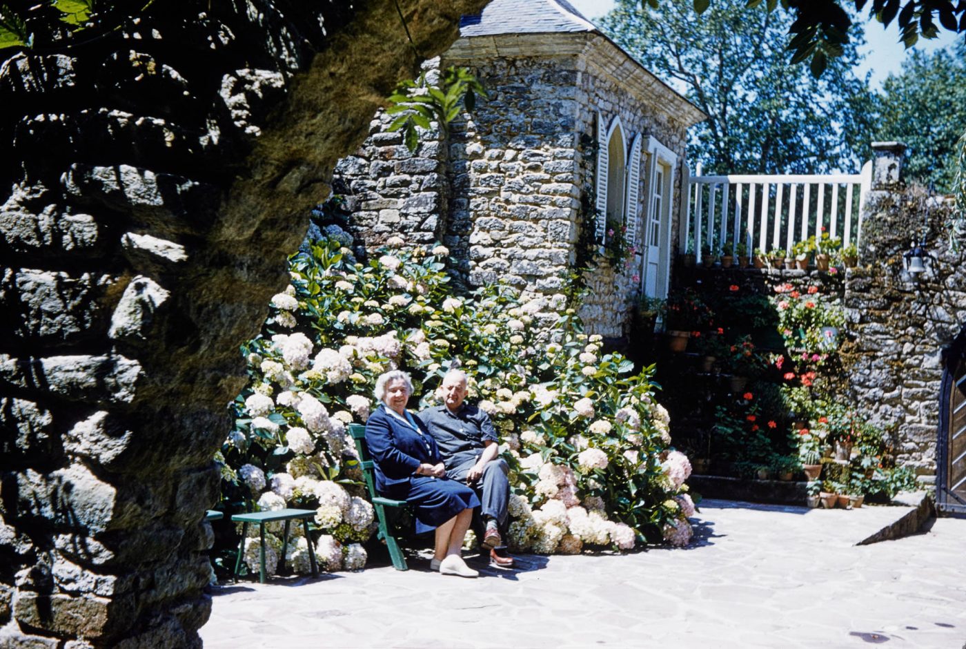 Jelena Djordjevic et Jean Royère sont assis au soleil devant un massif d'hortensias sur le domaine de Royère en Bretagne.