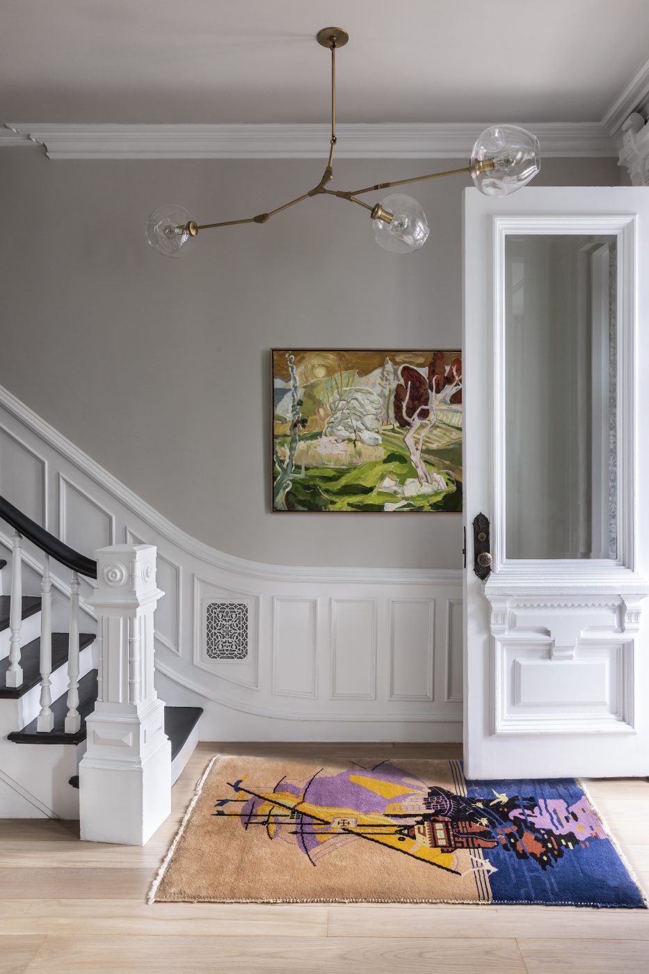 Dans le hall d'entrée, Studio SFW a introduit de la couleur et de l'intrigue sous la forme d'un lustre Lindsey Adelman Bubble à trois branches, d'un tapis Art déco représentant un voilier chinois et de l'œuvre d'art Descendant de Cubist, 2019, de Dai Ban.
