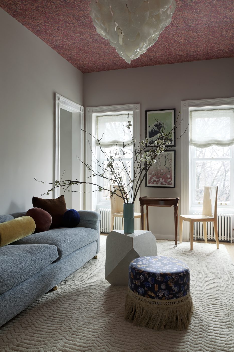 Occupant tout le dernier étage, la suite principale comprend un salon semblable à un sanctuaire avec des meubles anciens tels qu'un canapé moderne à dossier bas, un fauteuil Jindřich Halabala H269 des années 1930 pour Thonet et des chaises d'appoint en parchemin Karl Springer, qui sont associés à une table de jeu française des années 1940 à côté des fenêtres.  