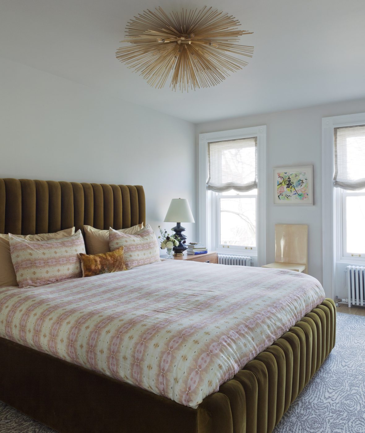 La chambre principale est équipée d'un lit en velours tufté sur mesure, avec des draps Eskayel, des tables de nuit Artifort de part et d'autre, et un luminaire Kelly Wearstler de style Spoutnik pour Visual Comfort qui rayonne au-dessus de la tête.